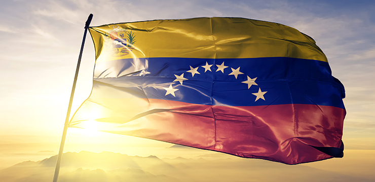 photo of Venezuelan flag with sun, sky and mountains in background