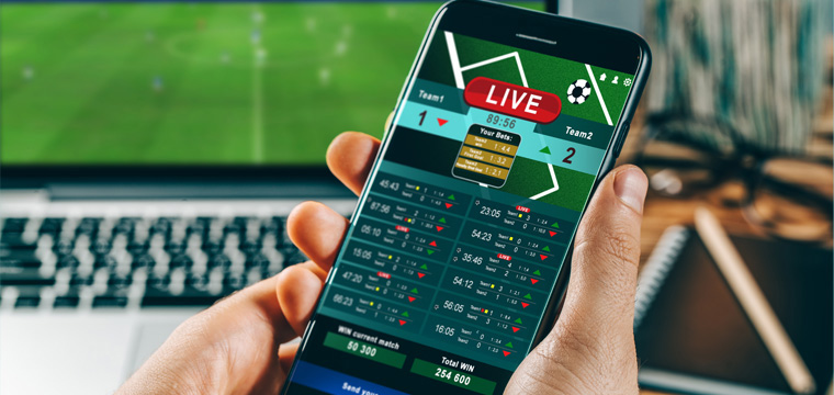 Hand holding smartphone with live sports betting